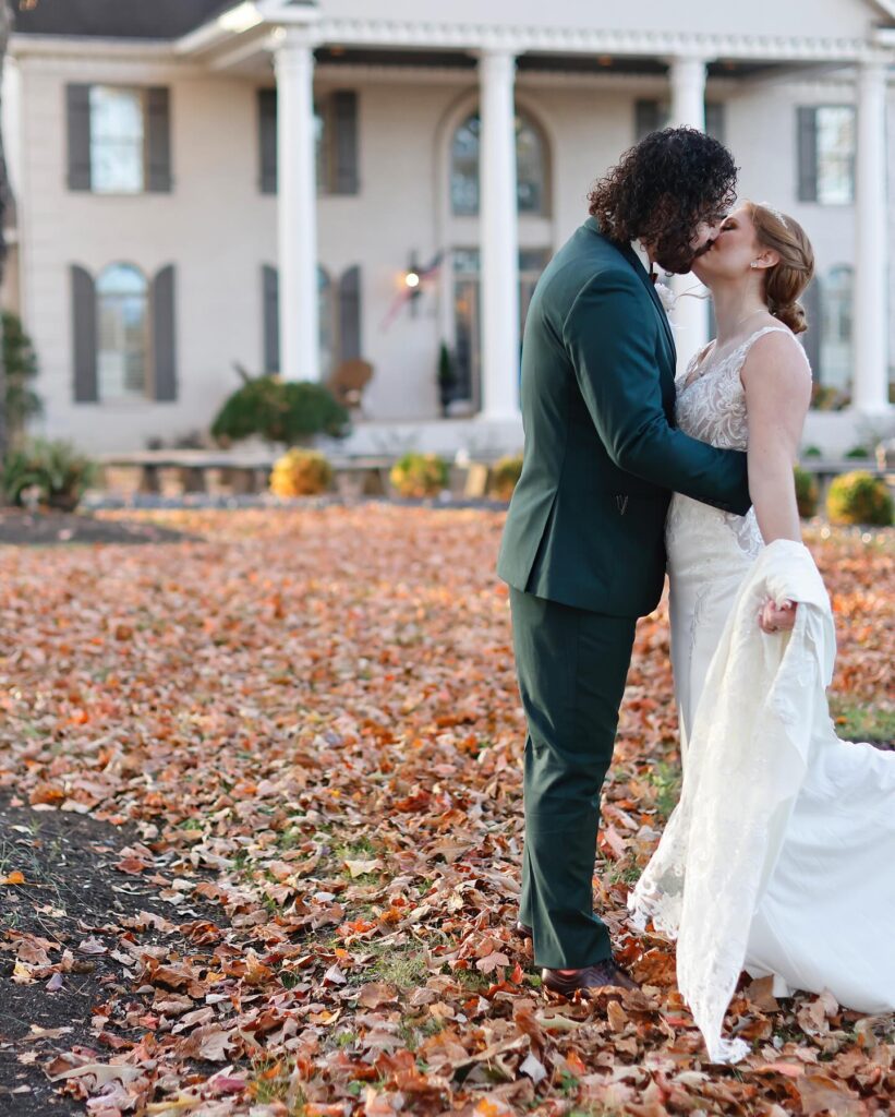 Bride and groom kissing in front of Treemont Mansion