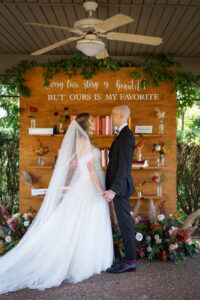 Bride and Groom in front of custom book wall